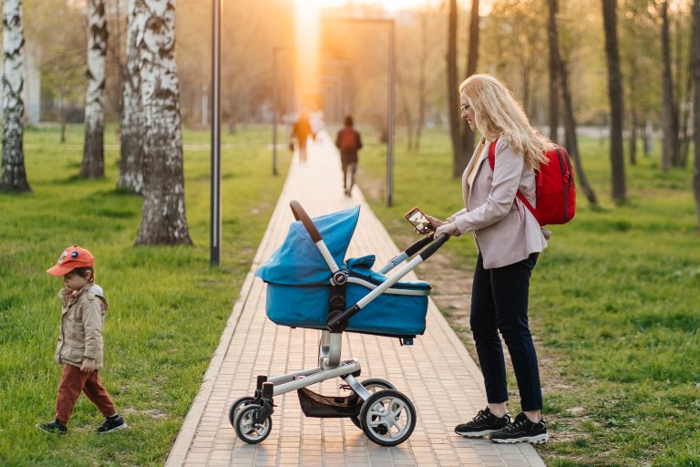 Podložka do kočárku: Praktický pomocník pro pohodlí i styl vašeho miminka 1 mom walks with stroller toddler son park