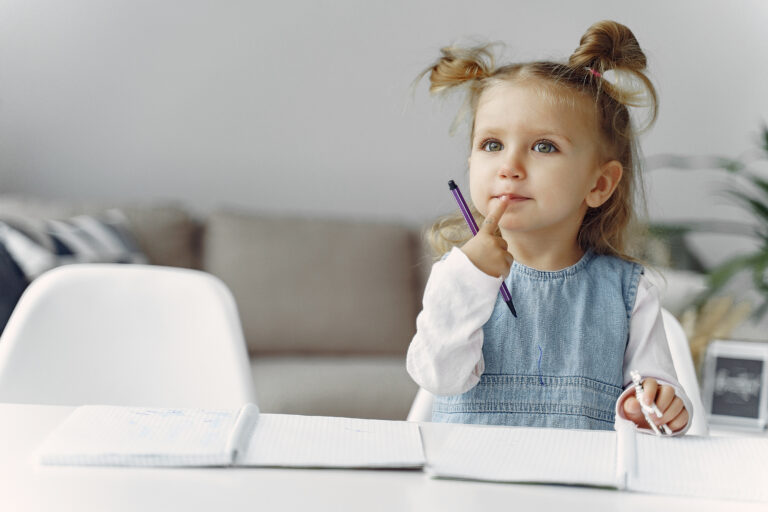little girl sitting table with books